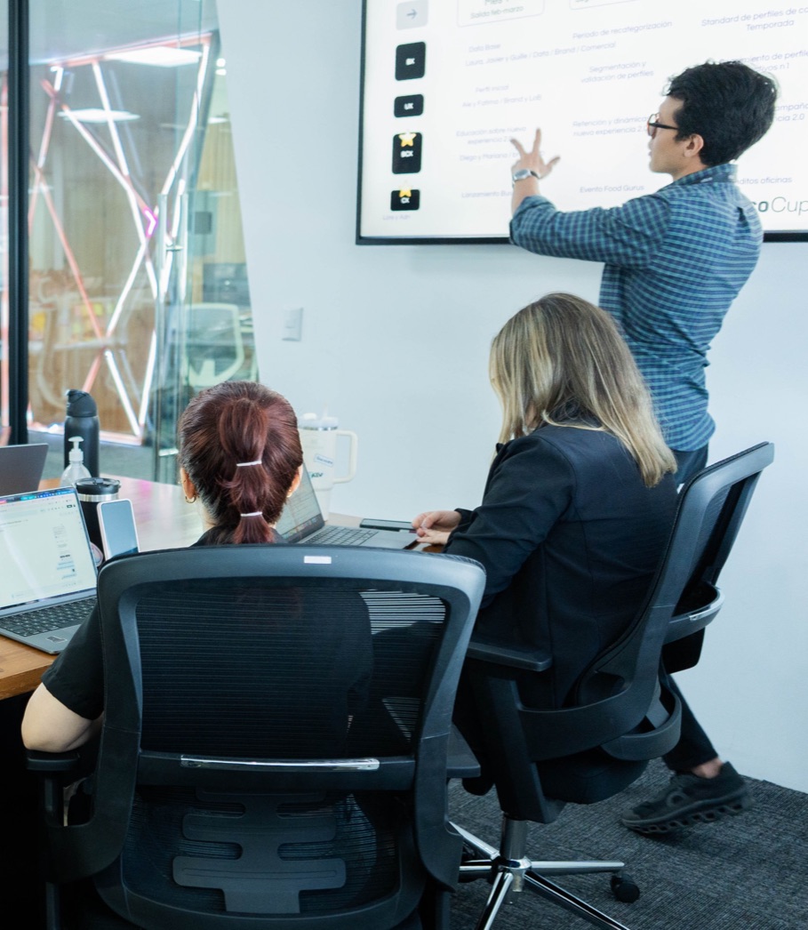 Un equipo de n1co en una reunión: una persona explica frente a una pantalla