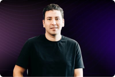 Hombre con camiseta negra sobre un fondo morado