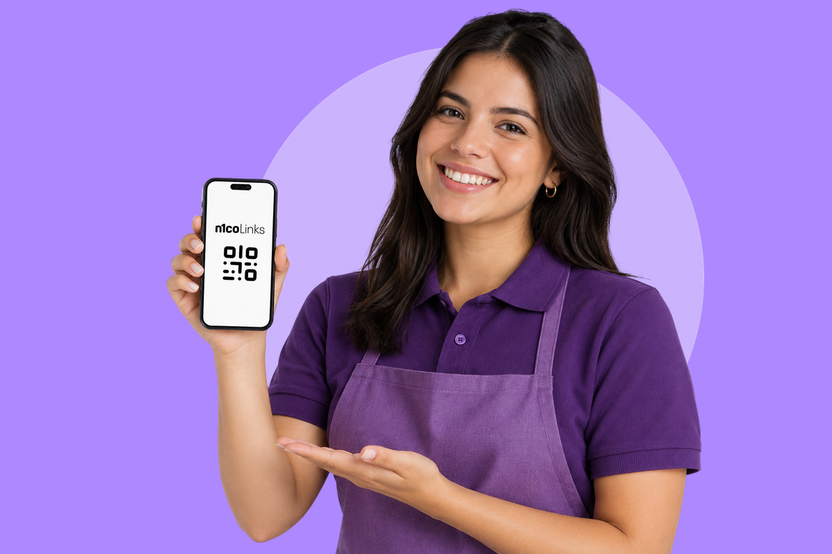 Comerciante con delantal morado que sonríe y muestra en su celular un QR de n1coLinks