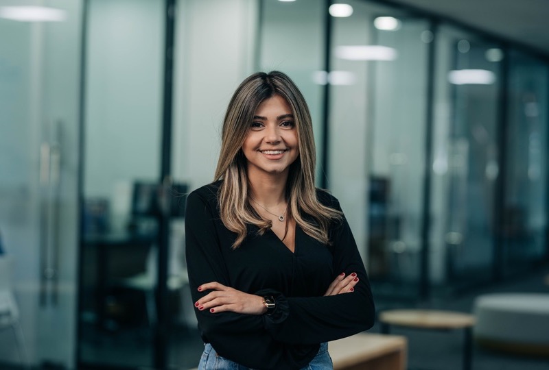 Una persona del equipo de n1co sonríe con los brazos cruzados en la oficina